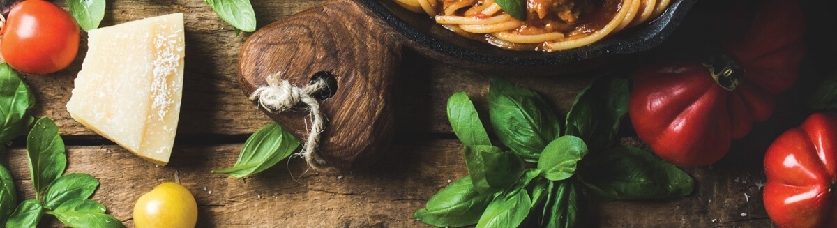 Cheese, basil and tomatoes on a wooden background.